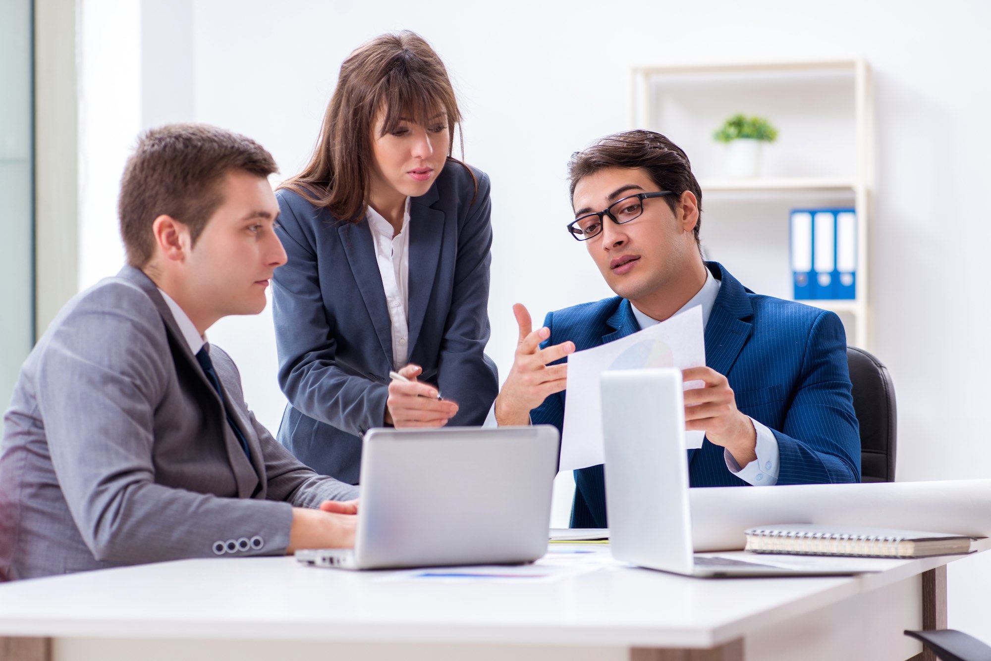 business meeting with three employees in an office