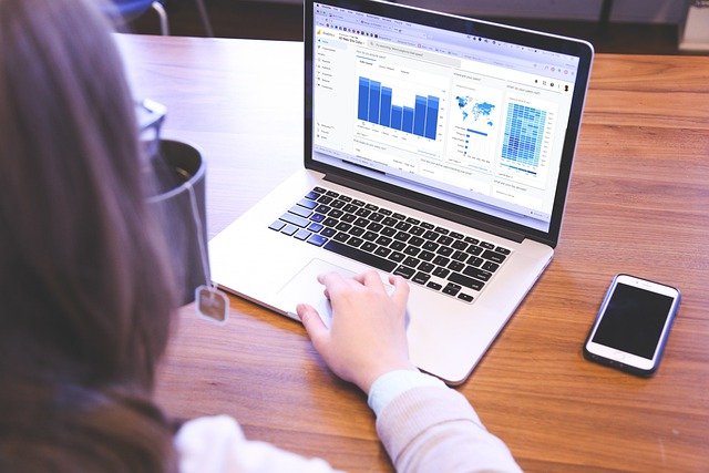 Woman working on computer with screen showing Google Analytics